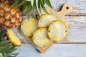 .Fresh pineapple fruit sliced Ã¢â¬â¹Ã¢â¬â¹on a wooden cutting board